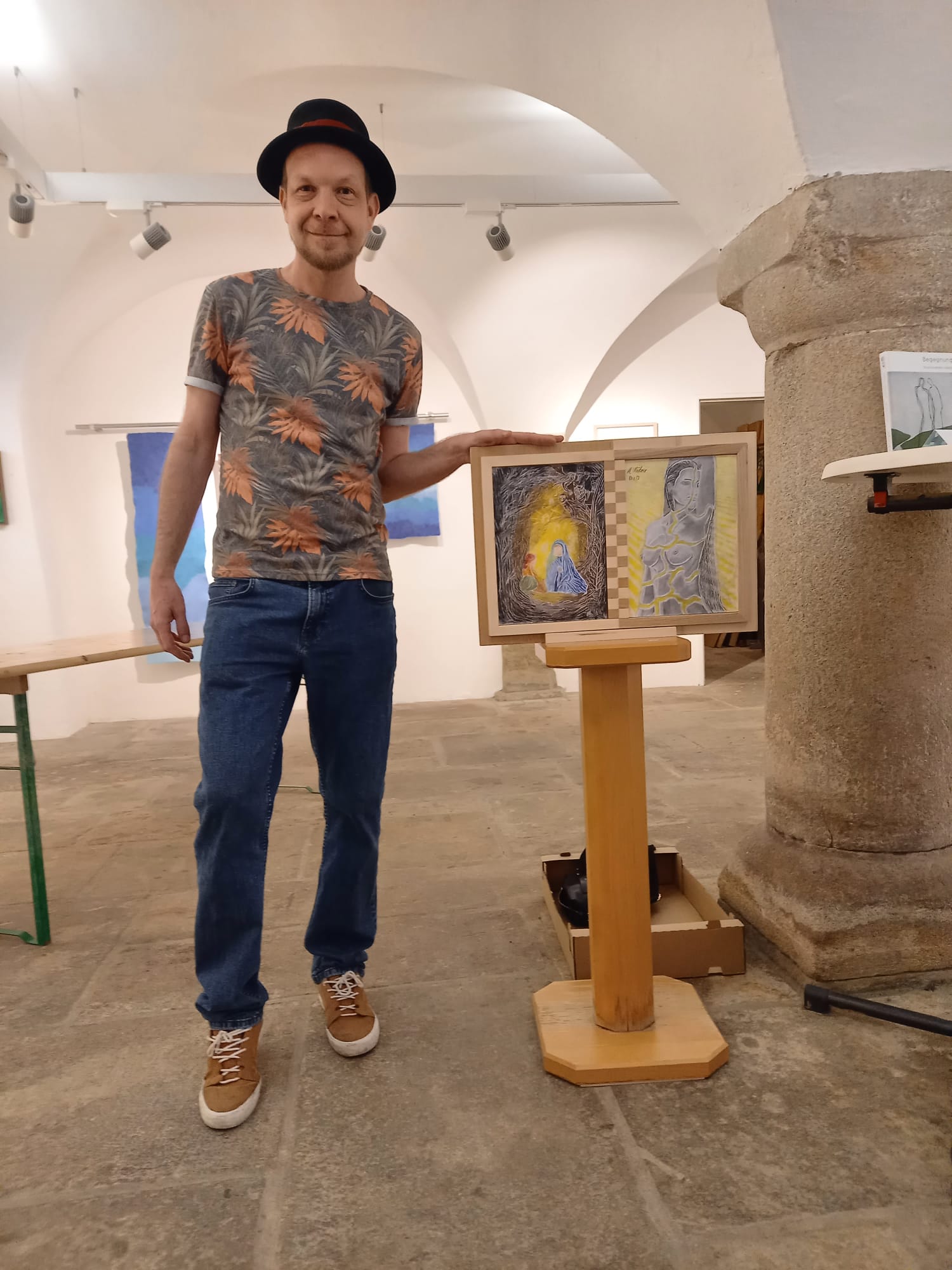 Matthias Wührer in seiner Ausstellung, neben einem seiner Werke